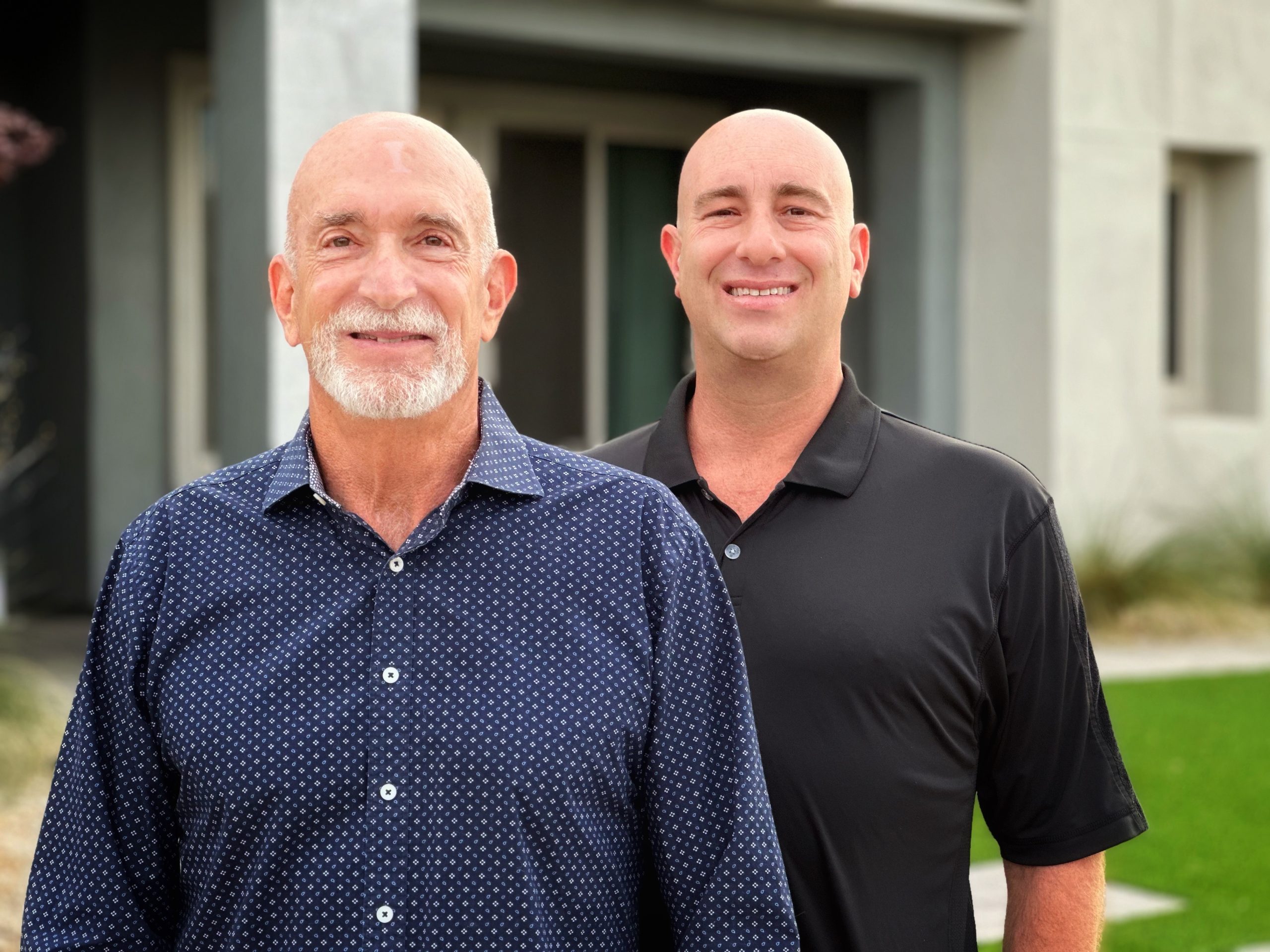 best-colorado-real-estate-brokers photo of Jerry Jacobs and Adam Jacobs, top performing real estate brokers in Colorado, wearing dark colored dress shirts in front of modern architecture